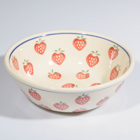 Cream ceramic bowl with red strawberry pattern, top view showing interior design with metallic rim