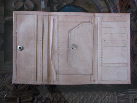 Open beige leather wallet displaying multiple card slots and compartments in flat lay view