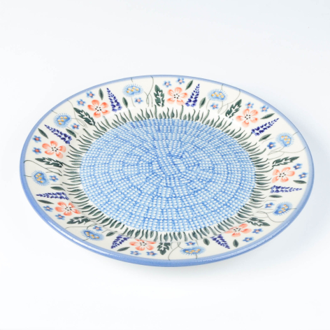 Light blue ceramic bowl with decorative border featuring small illustrated figures around the rim, angled top view