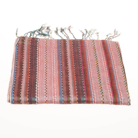 Red and cream striped textile with geometric patterns and natural fringe edges, folded flat in front view