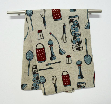 Cream linen textile with scattered kitchen utensil pattern in blue and red, draped over metal rod
