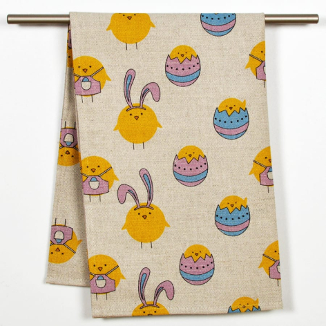 Cream cotton textile with repeating pattern of yellow suns, blue bowls, and brown hands, displayed draped on wooden rod