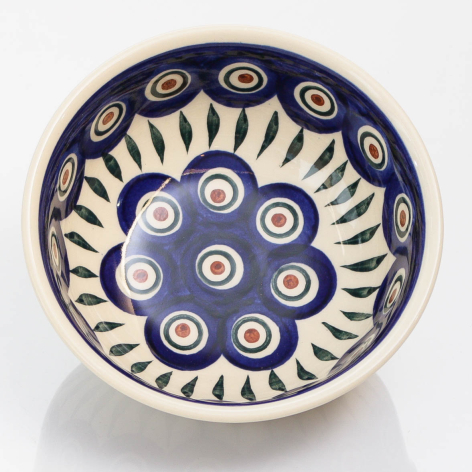 Deep blue ceramic bowl with cream-colored circular pattern and radiating sun design, overhead view