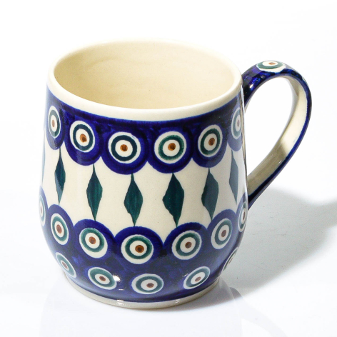Deep blue ceramic pitcher with cream interior, white circles and leaf motifs, curved handle