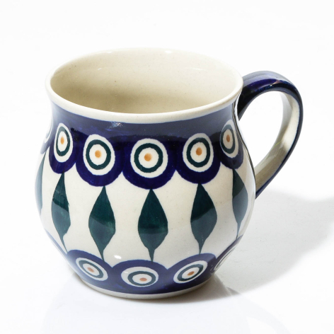 Blue and white ceramic pitcher with repeating leaf and circle pattern, cream interior, curved handle, front view