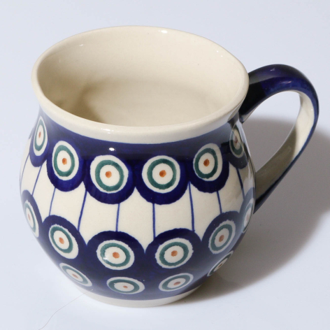Navy blue ceramic pitcher with white interior and repeating circle pattern design, shown from front angle