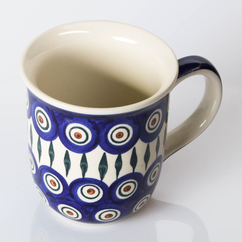 Navy blue ceramic mug with white circular motifs and cream interior, three-quarter view
