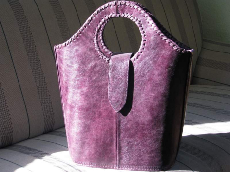 Pink velvet structured tote bag with curved handles and central keyhole detail, front view