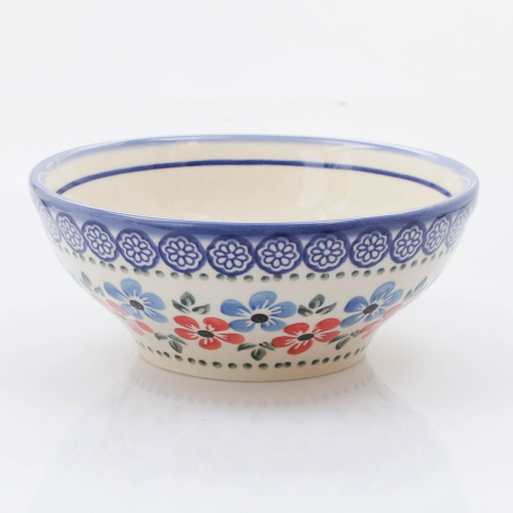 Blue and white ceramic bowl with colorful floral pattern band, front view