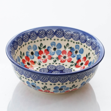 Blue and cream ceramic bowl with red and green floral pattern, viewed from above at slight angle