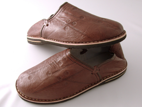 Brown leather slippers with textured surface and natural tan sole, shown from above angled view