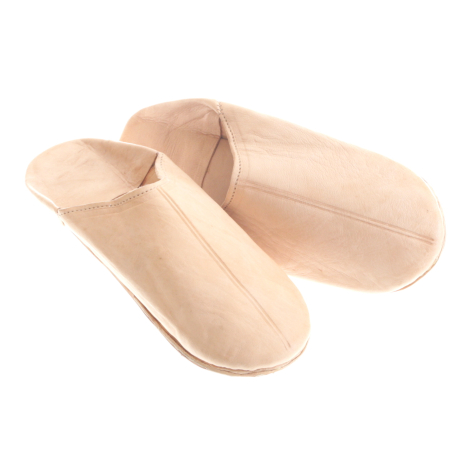 Pair of cream-colored leather slip-on shoes with soft molded soles, displayed at three-quarter angle