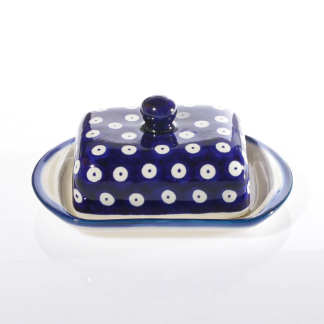 Navy blue ceramic butter dish with white polka dot pattern and matching lid knob, front view