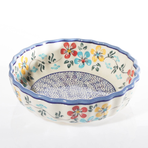 Cream ceramic bowl with blue rim, featuring colorful floral pattern and textured interior, angled front view