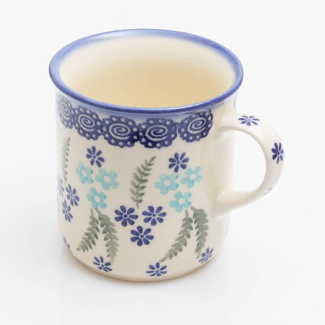 Cream enamel mug with blue floral pattern and matching rim, front view