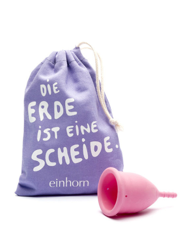Purple drawstring pouch with white text displayed next to a bright pink menstrual cup, front view