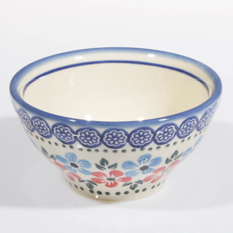 Blue and cream ceramic bowl with floral pattern detail around the lower half, viewed from front angle