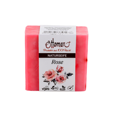Bright pink soap bars stacked with white label band featuring decorative floral design and product information