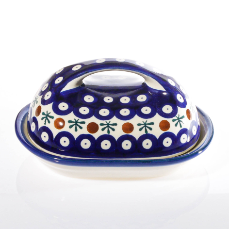 Deep blue ceramic bowl with white polka dot pattern and dual handles, viewed from front angle