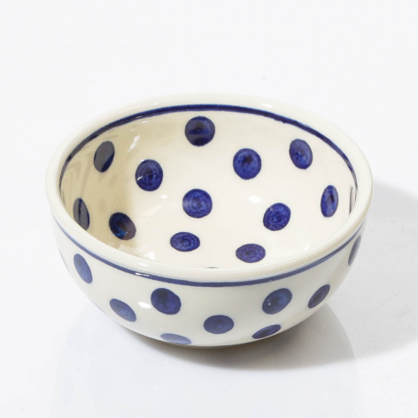 Blue and cream ceramic bowl with hand-painted polka dot pattern, viewed from above at slight angle