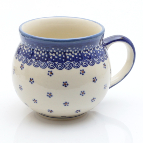 Cream ceramic mug with cobalt blue floral band and small scattered flowers, rounded shape with handle, front view