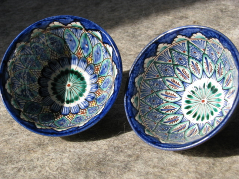 Two blue ceramic bowls with geometric patterns on concrete surface, viewed from above