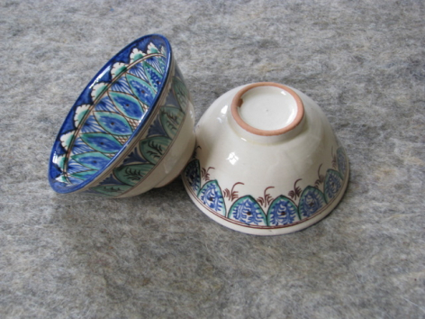 Blue and white ceramic bowls with hand-painted geometric patterns, displayed upside down to show interior decoration