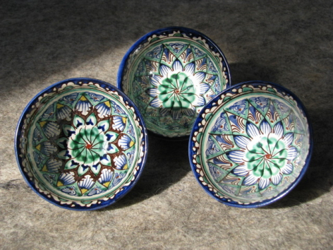 Three ceramic bowls with blue and green floral patterns, viewed from above on neutral background