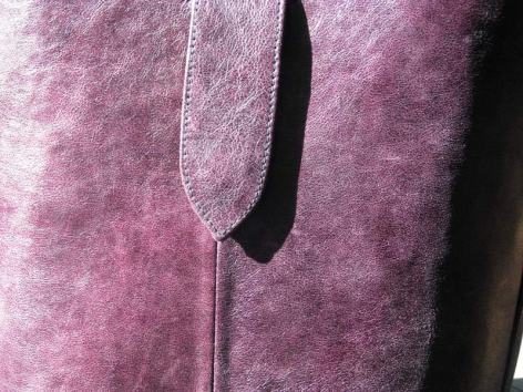 Mauve wool felt jacket with black trim detail at front opening, close-up of neckline and zipper area