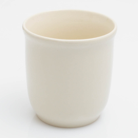 Cream ceramic cup with smooth cylindrical shape, front view on white background