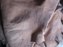 Gros plan sur une étoffe en coton gris clair froissée, montrant la texture naturelle et les plis du textile artisanal